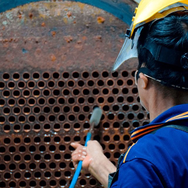 Técnico da Napratec limpando o espelho de tubos de uma caldeira com equipamento especial